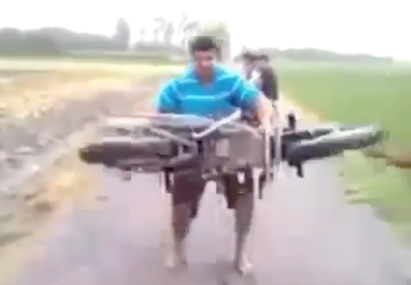REGARDEZ : Un homme soulève une moto au-dessus de sa tête