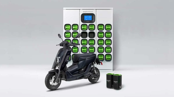 Un scooter électrique Yamaha devant une banque de batteries en charge