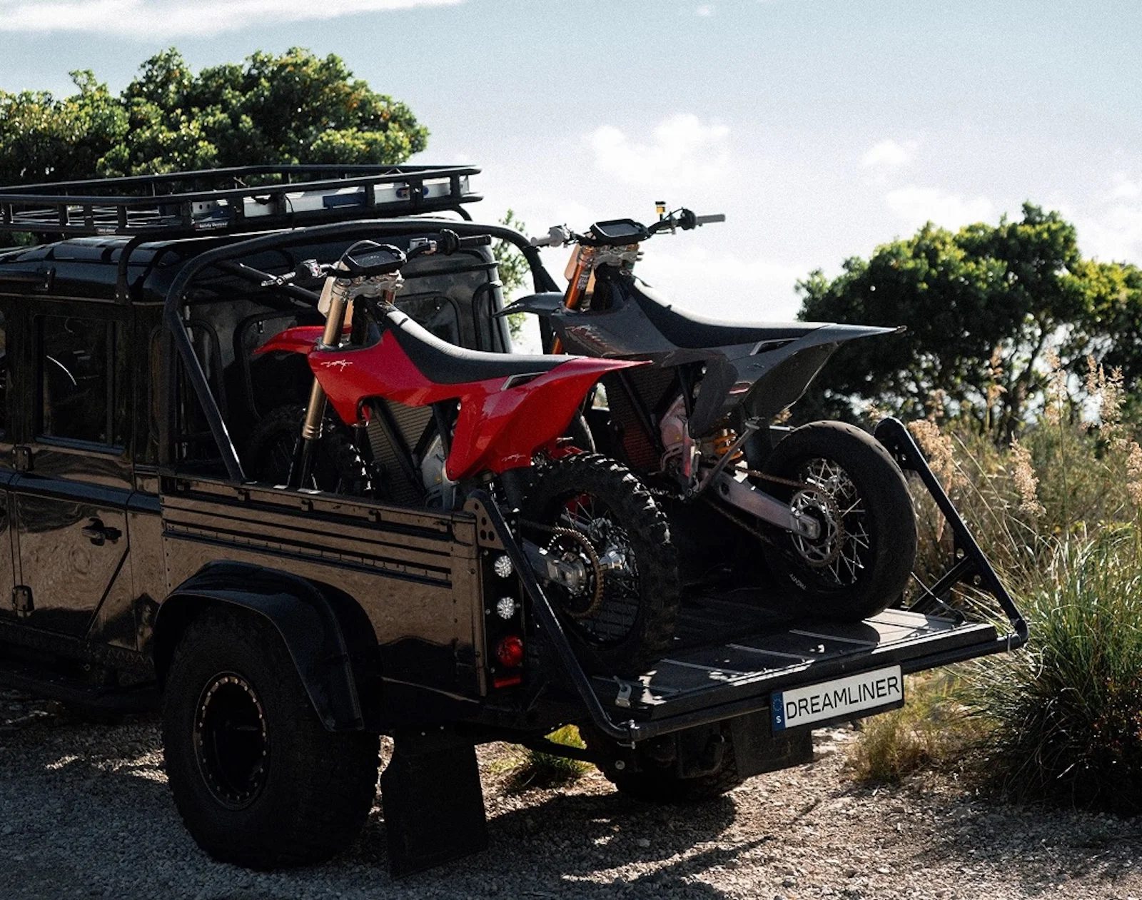Deux motos tout-terrain Stark Varg à l'arrière d'un pick-up Land Rover