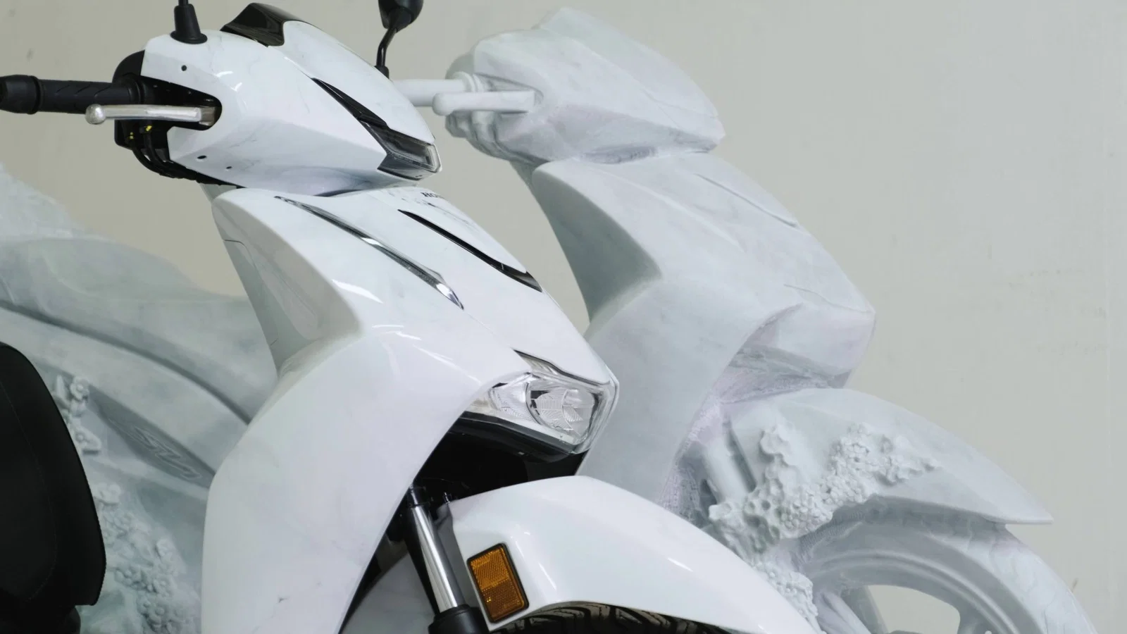 Une vue latérale de la sculpture et du scooter lui-même
