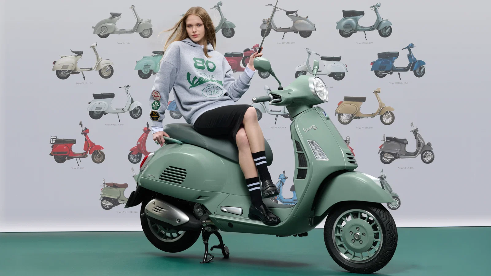 Scooter Vespa devant un mur sur le thème de la Vespa.