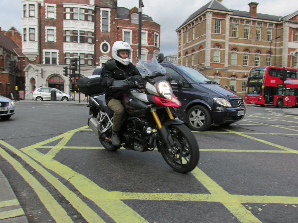 Motocycliste faisant un virage à l’intérieur d’une voiture.