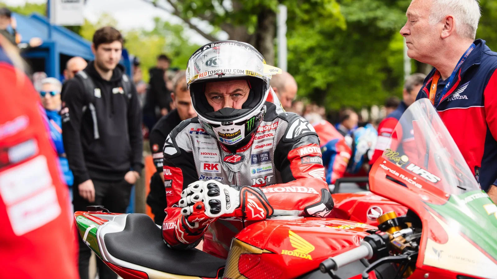 John McGuinness leaning on his Honda Superbike before a TT race