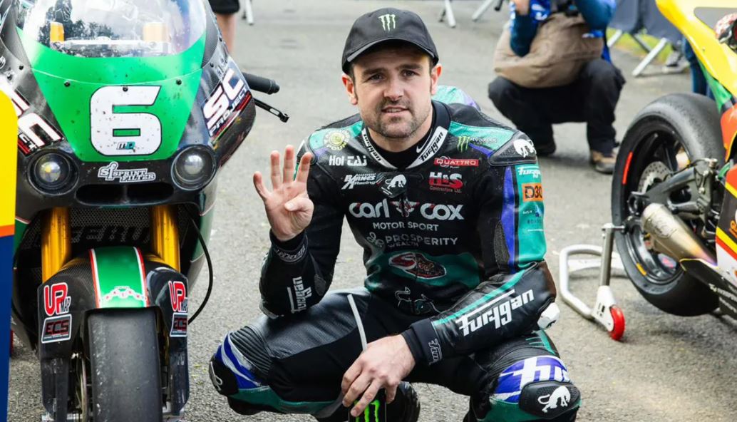 Michael Dunlop levant quatre doigts après avoir remporté quatre courses.