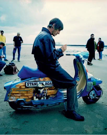 Paul Weller assis sur un scooter