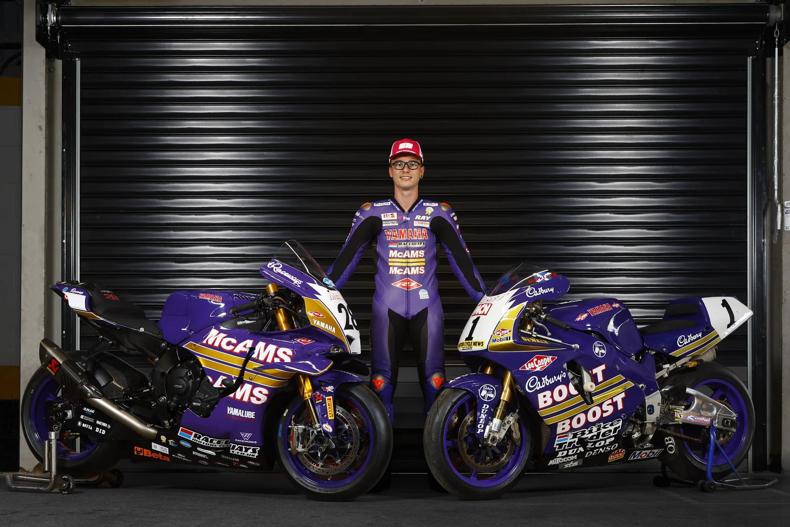 Bradley Ray debout avec sa McAMS Yamaha et le vélo Cadbury Boost d'origine.