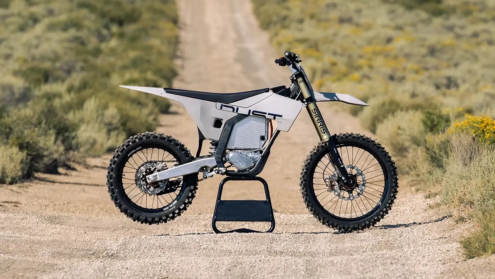A Dust Moto electric dirt bike on a dusty track